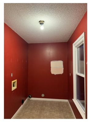 Red laundry room with popcorn ceiling